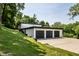 Three-car garage and concrete driveway, blending seamlessly with the surrounding landscape and mature trees at 6164 Afton Crest, Indianapolis, IN 46220