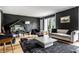 A stylish living room design with hardwood floors, neutral sofa, area rug, black accent wall and grand piano at 6164 Afton Crest, Indianapolis, IN 46220