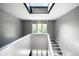 Bright stairway illuminated by a skylight and a window, featuring modern grey walls and carpeted steps at 6164 Afton Crest, Indianapolis, IN 46220