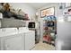 This functional laundry room features modern washer and dryer, and shelving for storage at 6315 Emerald Field Way, Indianapolis, IN 46221