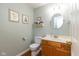 Charming half bathroom featuring a wood vanity, a round mirror, and decorative wall accents at 6683 Manchester Dr, Fishers, IN 46038