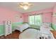 Cozy bedroom with two twin beds, hardwood floors, and a window providing natural light at 6683 Manchester Dr, Fishers, IN 46038