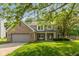 Charming two-story home featuring a brick facade, attached garage, and a well-maintained lawn with mature trees at 6683 Manchester Dr, Fishers, IN 46038