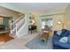 Comfortable living room with an open floor plan, staircase, and a cozy seating area with a blue sofa at 6683 Manchester Dr, Fishers, IN 46038