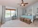 Spacious main bedroom with a four-poster bed, sitting area near the window, and a ceiling fan at 6683 Manchester Dr, Fishers, IN 46038