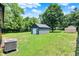 Spacious backyard featuring a detached garage, central air conditioning unit, and ample green space at 6949 Crittenden Ave, Indianapolis, IN 46220