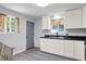 Bright kitchen featuring white cabinets, stainless steel appliances, and laminate floors at 6949 Crittenden Ave, Indianapolis, IN 46220