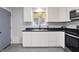 Well-lit kitchen with white cabinetry, modern appliances and gray vinyl plank flooring at 6949 Crittenden Ave, Indianapolis, IN 46220