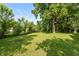 Large grassy backyard with mature trees and open space at 7139 Buick Dr, Indianapolis, IN 46214