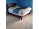 Bedroom featuring a blue wall, bed, carpet, and a wooden headboard at 721 Maplewood Ave, Anderson, IN 46012