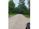 Long driveway leading to a home surrounded by mature trees and green lawns at 721 Maplewood Ave, Anderson, IN 46012
