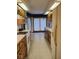 Galley kitchen with white appliances, wood cabinets, and a door to the outside at 721 Maplewood Ave, Anderson, IN 46012