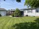 Backyard featuring a well-manicured lawn, mature landscaping, and access to the house and garage at 737 Howard St, Shelbyville, IN 46176