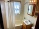 Well-lit bathroom with a shower-tub combo and a classic wooden vanity at 737 Howard St, Shelbyville, IN 46176
