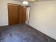 Spacious bedroom featuring soft carpet, a ceiling fan, and a convenient closet with folding doors at 737 Howard St, Shelbyville, IN 46176