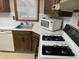 Close-up of kitchen featuring stainless steel sink, gas range, and white appliances, perfect for cooking enthusiasts at 737 Howard St, Shelbyville, IN 46176