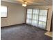 Bright living room with large windows, ceiling fan, and neutral carpeting, ready for your personal touch at 737 Howard St, Shelbyville, IN 46176