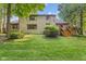 Spacious backyard featuring a brick home with a wooden deck and lush green lawn at 7612 Freedom Woods Dr, Indianapolis, IN 46259