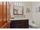 Bathroom featuring stylish vanity with stone countertop, decorative mirror and modern wall fixtures at 7612 Freedom Woods Dr, Indianapolis, IN 46259
