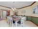 Spacious dining room with chandelier, wainscotting, carpet and a large dark wood table at 7612 Freedom Woods Dr, Indianapolis, IN 46259