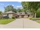 Charming brick home featuring a well-manicured lawn, mature trees and an expansive driveway at 7612 Freedom Woods Dr, Indianapolis, IN 46259