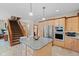 Bright kitchen features a granite island, stainless steel appliances, and stairs to the second floor at 7612 Freedom Woods Dr, Indianapolis, IN 46259