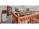 Carpeted loft featuring wood banisters with bookshelves, windows, and views of the living spaces below at 7612 Freedom Woods Dr, Indianapolis, IN 46259