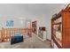 Carpeted loft featuring wood banisters with bookshelves, windows, and views of the living spaces below at 7612 Freedom Woods Dr, Indianapolis, IN 46259
