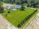 Aerial view of the property, showcasing the manicured lawn, pool, home, and a line of mature trees at 7728 W 200 S, New Palestine, IN 46163