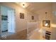 Upstairs hallway with white banister, hardwood floors, and open doorway to a room with a bookshelf at 7728 W 200 S, New Palestine, IN 46163