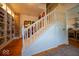 Elegant staircase with white railings and wooden floors, complemented by a charming reading nook at 7728 W 200 S, New Palestine, IN 46163