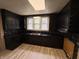A kitchen with black cabinetry and stainless steel sink, ready for your personalization at 807 N Elm St, Muncie, IN 47305