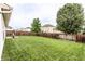 Large backyard with a well-maintained lawn, a wood fence for privacy, and mature trees to provide shade at 8116 Harshaw Dr, Indianapolis, IN 46239