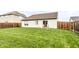 Large backyard with lush grass, a wood fence, and a view of the back of the house at 8116 Harshaw Dr, Indianapolis, IN 46239