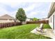 Serene backyard featuring a well-manicured lawn, a wooden fence, and rocking chairs on a concrete patio at 8116 Harshaw Dr, Indianapolis, IN 46239
