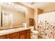 Bright bathroom featuring a double vanity, decorative shower curtain, and neutral wall color at 8116 Harshaw Dr, Indianapolis, IN 46239