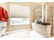 Bright bathroom features a soaking tub, glass-enclosed shower, and large window at 8116 Harshaw Dr, Indianapolis, IN 46239