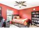 Bright bedroom with red walls, a full bed, and a built-in bookshelf at 8116 Harshaw Dr, Indianapolis, IN 46239