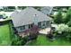 Back exterior view featuring a deck with outdoor seating and a hot tub surrounded by a well-maintained lawn at 8144 Grassy Meadow Cir, Indianapolis, IN 46259