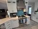 Bright kitchen featuring an electric range and decorative blue backsplash at 8144 Grassy Meadow Cir, Indianapolis, IN 46259