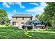 Backyard view of the home featuring a stone patio, grill, hot tub, and lounging furniture at 8261 Twin Pointe Cir, Indianapolis, IN 46236