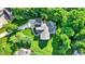 Aerial view of backyard with a stamped concrete patio, hot tub, comfortable seating area, and lush lawn surrounded by trees at 8261 Twin Pointe Cir, Indianapolis, IN 46236