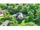 Aerial view of backyard with a stamped concrete patio, hot tub, comfortable seating area, and lush lawn surrounded by trees at 8261 Twin Pointe Cir, Indianapolis, IN 46236
