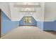 A bedroom features blue walls, neutral carpet, and a bright window at 8261 Twin Pointe Cir, Indianapolis, IN 46236