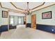 Traditional dining room featuring wainscoting, wood trim, light green walls, and an elegant chandelier at 8261 Twin Pointe Cir, Indianapolis, IN 46236