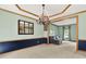 Dining room boasts a decorative chandelier, wainscoting, a mirror, and an opening to another room at 8261 Twin Pointe Cir, Indianapolis, IN 46236