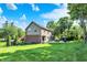 View of home's back exterior, patio area, and well-manicured lawn on a sunny day at 8261 Twin Pointe Cir, Indianapolis, IN 46236
