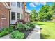 Close-up of a brick home with attractive landscaping, including flowering plants and a well-maintained lawn at 8261 Twin Pointe Cir, Indianapolis, IN 46236