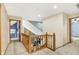 Bright hallway featuring wood railing overlooking the living room below, with open doorways at 8261 Twin Pointe Cir, Indianapolis, IN 46236