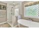 Elegant main bathroom featuring a soaking tub, glass-enclosed shower, and decorative window at 8261 Twin Pointe Cir, Indianapolis, IN 46236